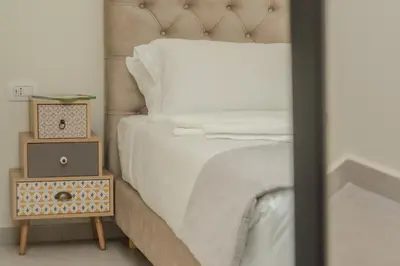 a bedroom with a bed and a night stand with a alarm clock at Cozy Spot II near the beach in Ayiá
