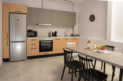 a kitchen with a table with chairs and a refrigerator at Vesta suite&studio in Chania Old Town in Chania Town